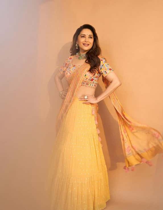 Fashion inspiration to all those, who want to sport ethnic wear like a chic goddess. Here, Madhuri has worn a mustard yellow lehenga with a multicoloured top and dupatta. She has styled it with a statement necklace piece.
