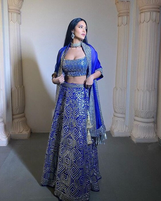 The blue lehnga with the hot blouse with statement jewellery pieces makes her look desirable.