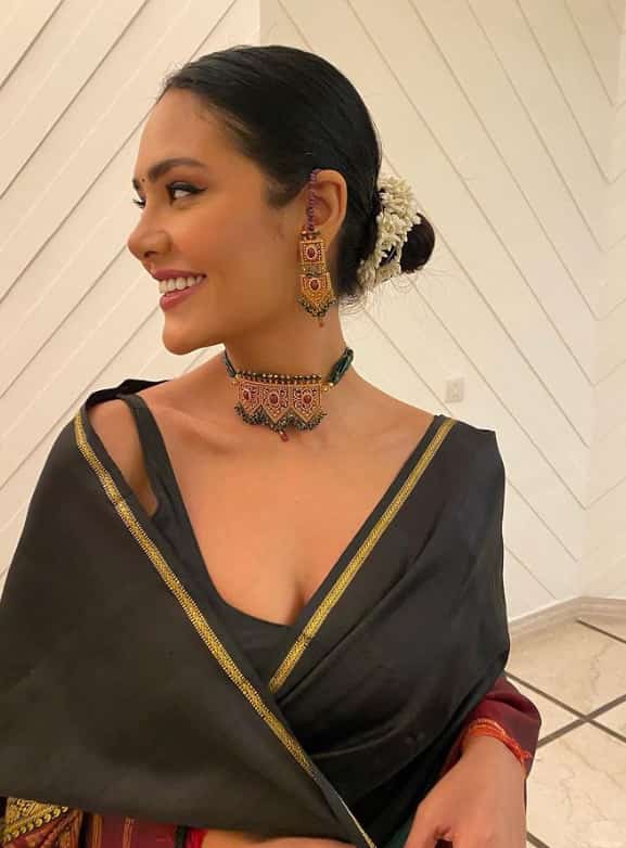 The all-black saree with black choker and earrings makes the actress look beautiful.