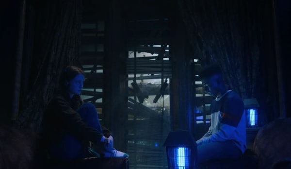 The air seems intense between Max and Lucas in this dark room.