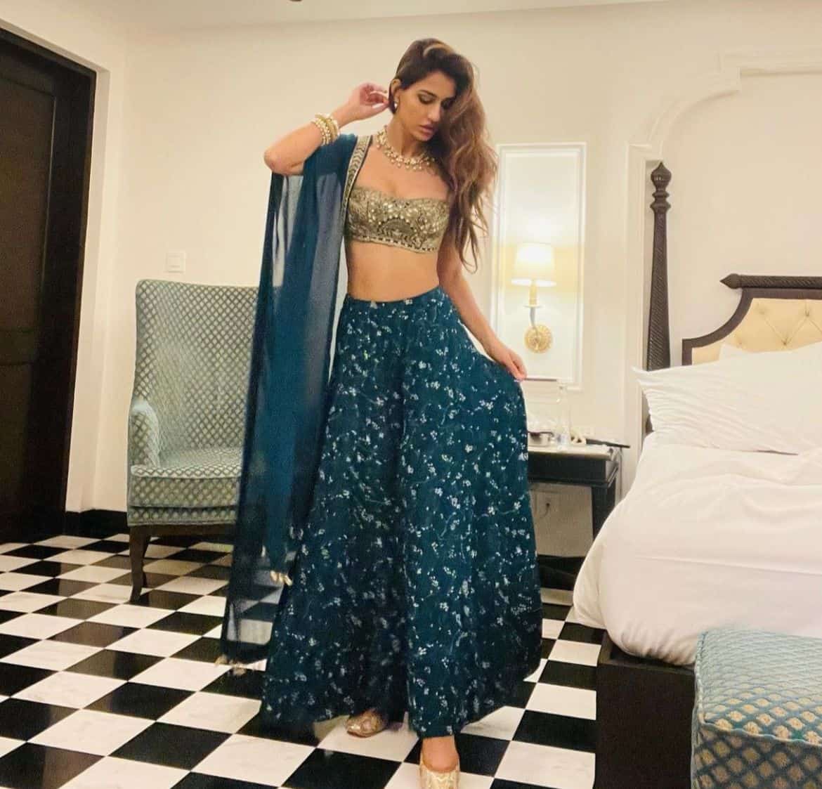 5. Disha Patani poses in her turquoise and gold lehenga. She looks stunning in this Indian attire.