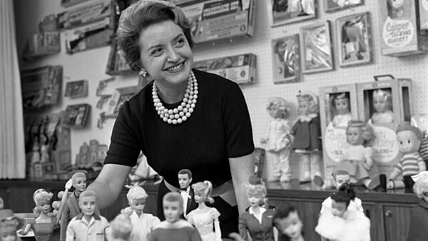 A 1961 photograph of Ruth Handler, an executive with Mattel and the inventor of the Barbie doll, posing with a collections. Image via Wikimedia Commons
