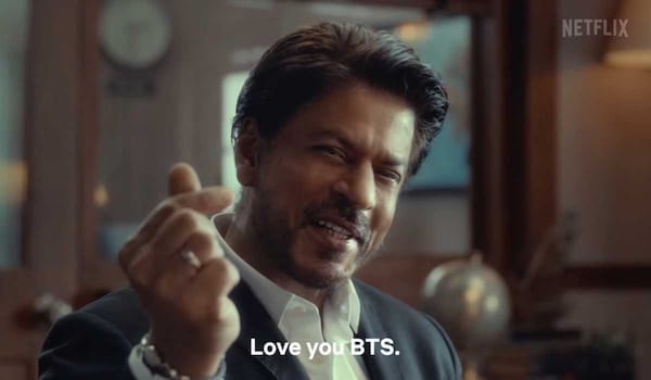 Dunki on Netflix - Shah Rukh Khan humorously claims to have taught South Koreans about love; shows a finger heart to BTS