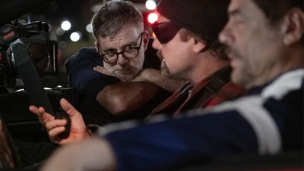 From top: Still from One Battle After Another featuring Leonardo DiCaprio and Benicio Del Toro; PTA directing the two actors during the film shoot.