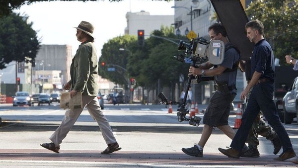 From top: Still from Inherent Vice featuring Joaquin Phoenix and Joanna Newsom; PTA directing Phoenix in a scene from the film.